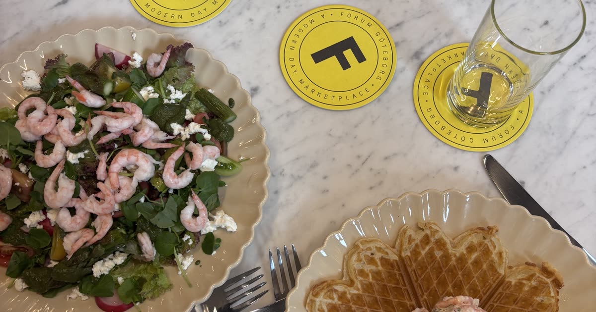 Interiör på Forum Mat och Dryck med marmorbord, svarta stolar och konstvägg av Karolina Palmér i Gamlestadens Fabriker, Göteborg